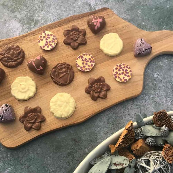 Milk and white chocolate flowers displayed on a tray.