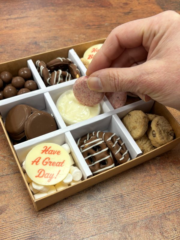 Happy Birthday grazing box with a hand dipping chocolate into the dip